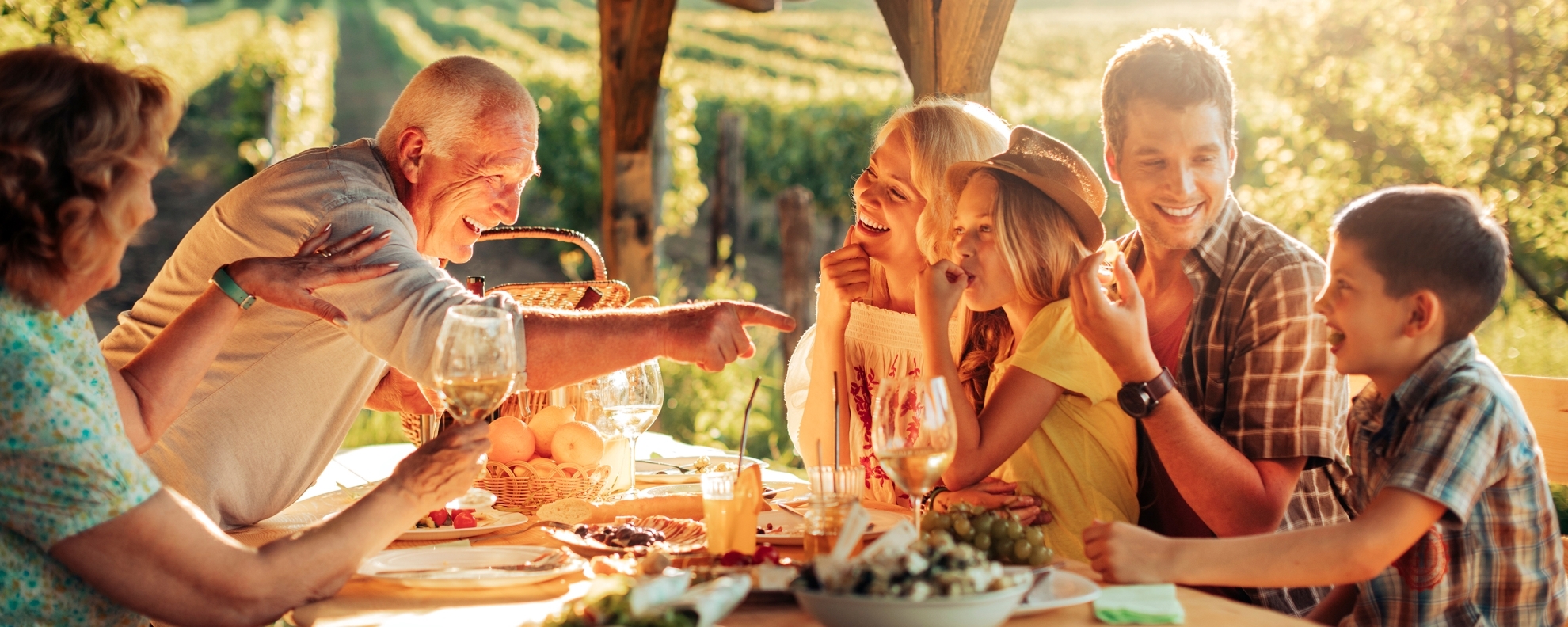 Multi-generational family gathered around outdoor table